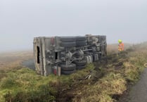 Lorry ends up on its side in field