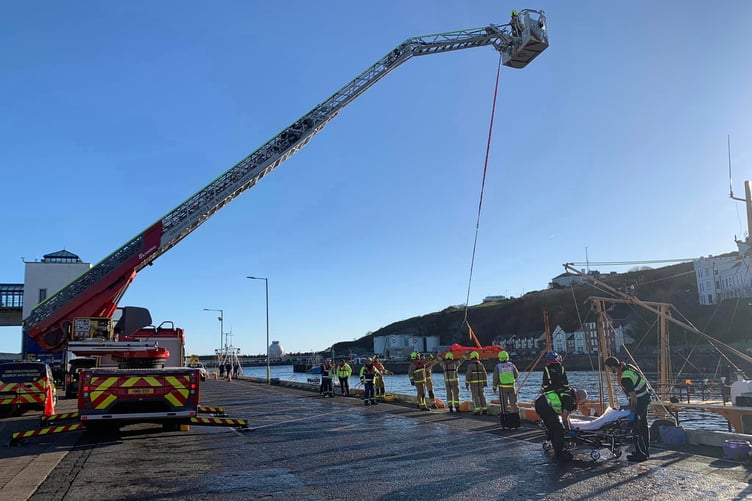 Fire service crews extract an injured crew member from a fishing boat