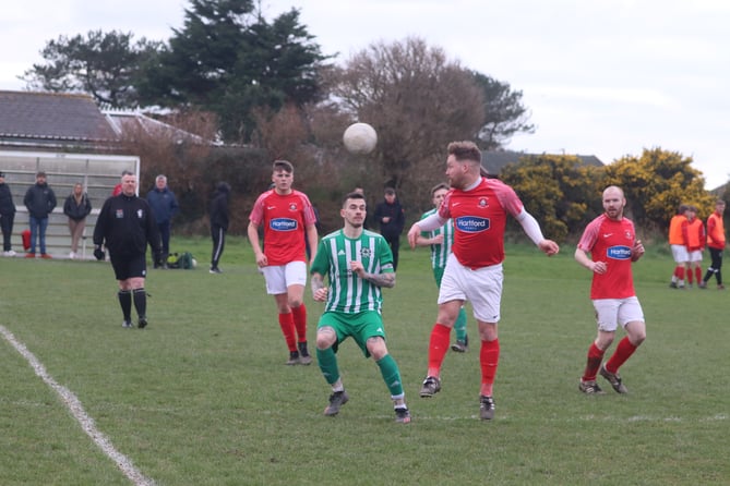 Castletown MFC's Ash Sansbury heads clear against Michael United