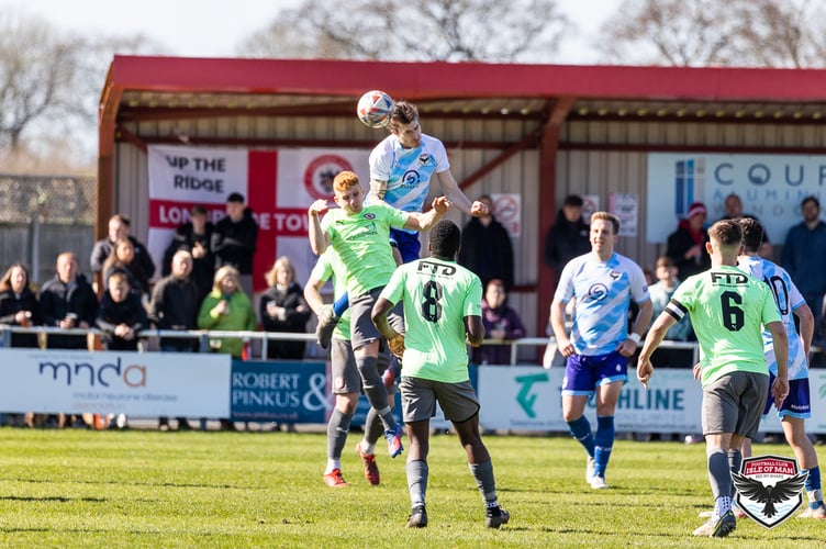 Goalscorer Mike Williams wins a header against Longridge Town