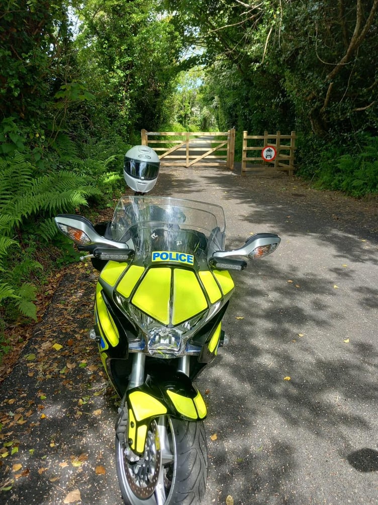 Police bike in front of wooden gate
