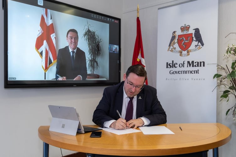 Minister for Health and Social Care, Lawrie Hooper MHK, signing the RHA with The Minister of State for Health and Secondary Care, Will Quince MP.