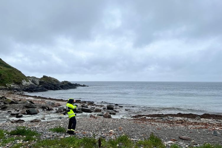 A member of the Peel coastguard team scans the sea for the object
