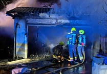 Dozen firefighters tackle blaze at garage with 'multiple vehicles' 