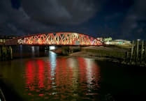 Tower of Refuge and Ramsey Swing Bridge both lit up red for World Encephalitis Day