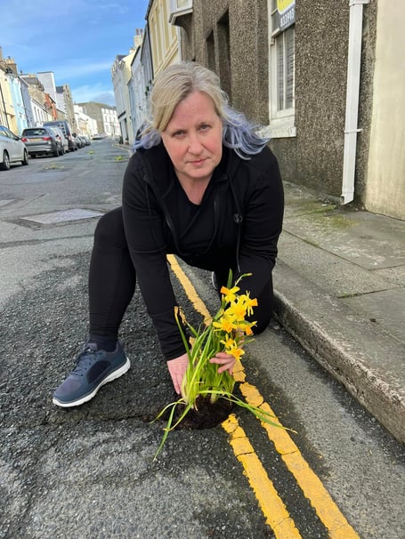 Michelle Haywood fulfilled her promise to plant daffodils in potholes on a main road in the south of the island