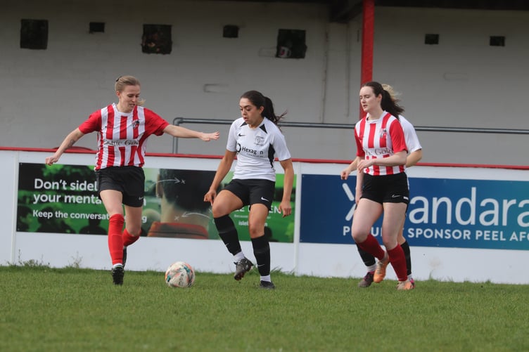 Corinthians' Holly Stephen (centre) is closely watched by Peel's Louise Gibbins (left) and Jenny Metcalfe (right)