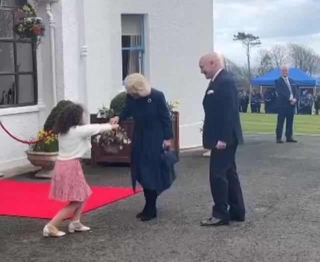Watch the moment Queen Camilla is presented with flowers by schoolgirl