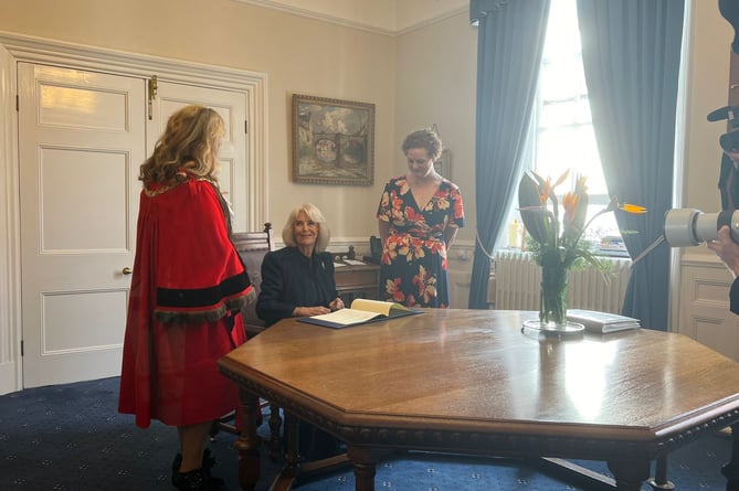 Queen Camilla signing the Letters Patent to officially confer city status upon Douglas