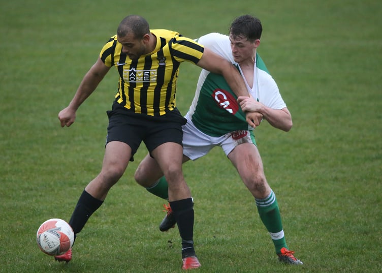 Rushen United's Furo Davies grapples with Laxey's Tom Cowin during Saturday's Premier League encounter between the pair at Croit Lowey. Rushen travel to St Mary's in the FA Cup semi-finals this weekend (Photo: Brian Goldie)