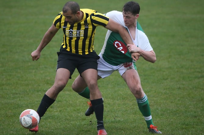 Rushen United's Furo Davies grapples with Laxey's Tom Cowin during Saturday's Premier League encounter between the pair at Croit Lowey. Rushen travel to St Mary's in the FA Cup semi-finals this weekend (Photo: Brian Goldie)