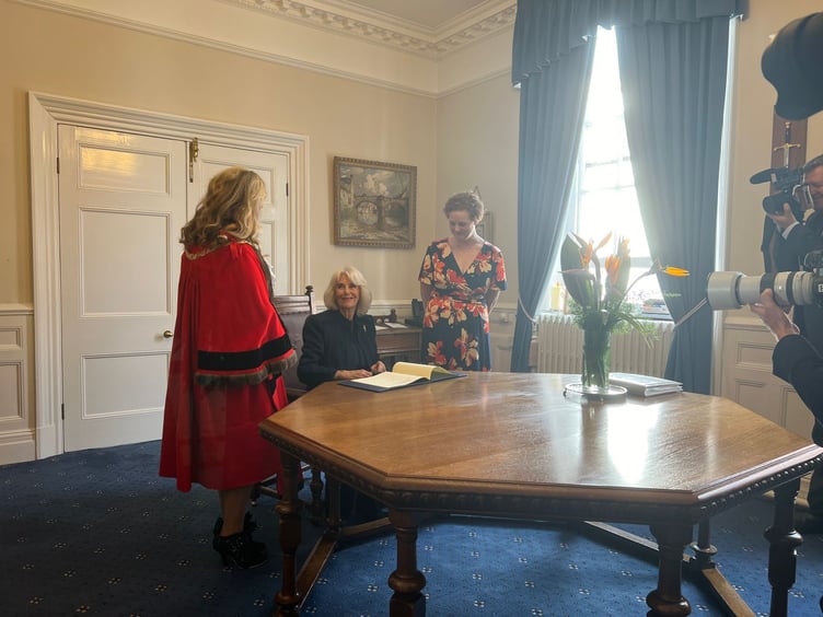 Her Majesty Queen Camilla signing the Letters Patent which confirmed Douglas as a city
