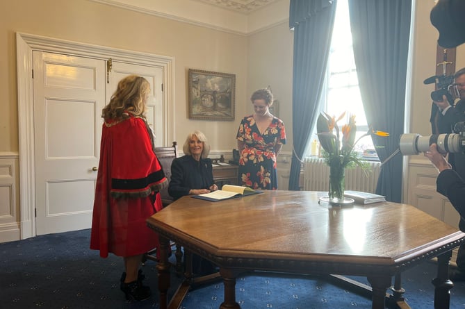 Her Majesty Queen Camilla signing the Letters Patent which confirmed Douglas as a city