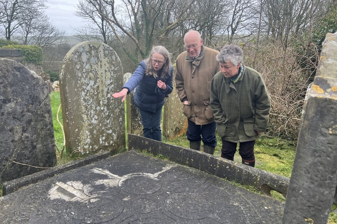 Rosemary Gibson with Sir John Lorimer and Lady Lorimer looking over a historic grave at the Old St Runius Way in Crosby.