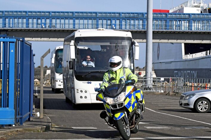 The first group of repatriated residents arrive in the island under police escort following the border closure in April 2020