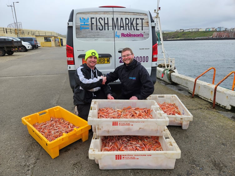 John Henley (skipper of New Dawn PL1) handing langoustines caught using creels to Jay Gore of Robinsons Fresh Foods IOM.