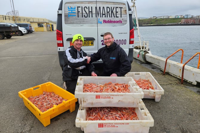 John Henley (skipper of New Dawn PL1) handing langoustines caught using creels to Jay Gore of Robinsons Fresh Foods IOM.