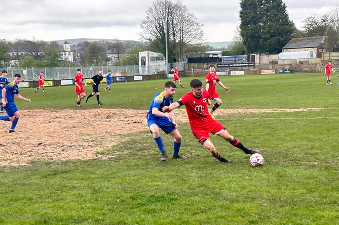 FC Isle of Man's Jacob Crook attempts to hold off a Barnoldswick Town opponent during Saturday afternoon's clash at the Silentnight Stadium (Photo: Sam Turton)