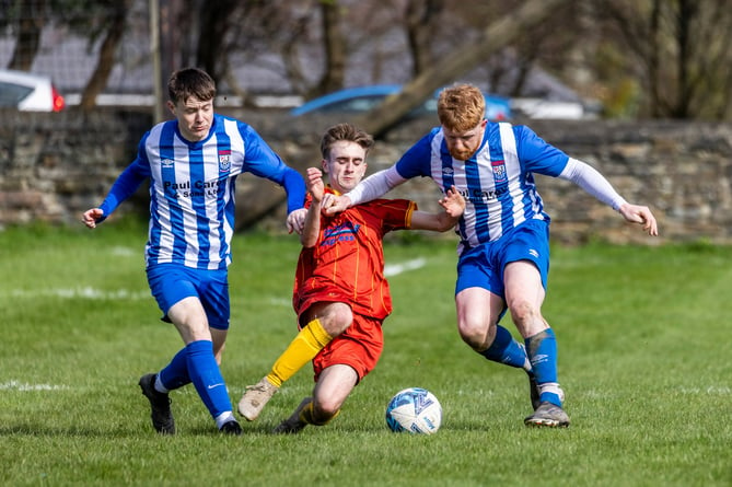Marown's Tom Redmond (centre) challenges Ramsey's Dom Parish during last Saturday's Canada Life Premier League clash which ended 1-1. Redmond impressed to earn his place in Team of the Week (Photo: Gary Weightman)