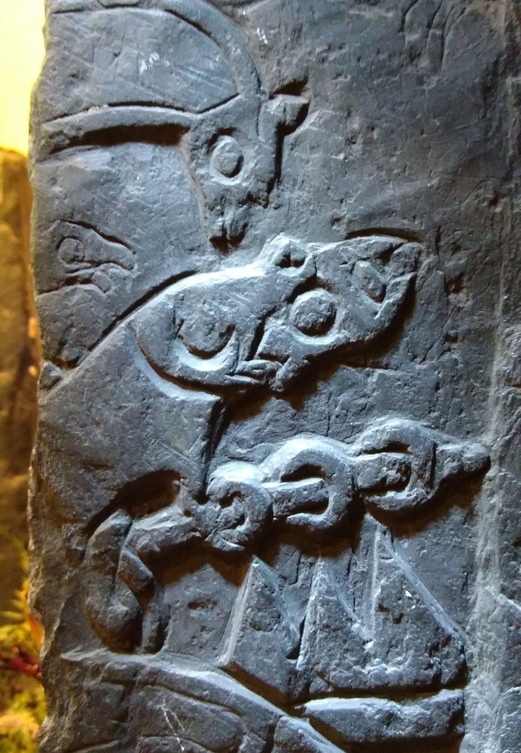 Detail from the fragment of cross showing Odin burning his fingers while roasting the dragon's heart