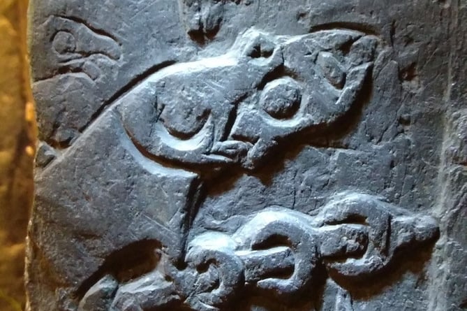 Detail from the fragment of cross showing Odin burning his fingers while roasting the dragon's heart