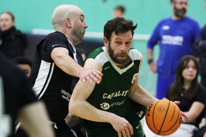 Phil Evans drives past Paul Kilic on his way to the hoop for Cavaliers in their hard-fought game against Jets