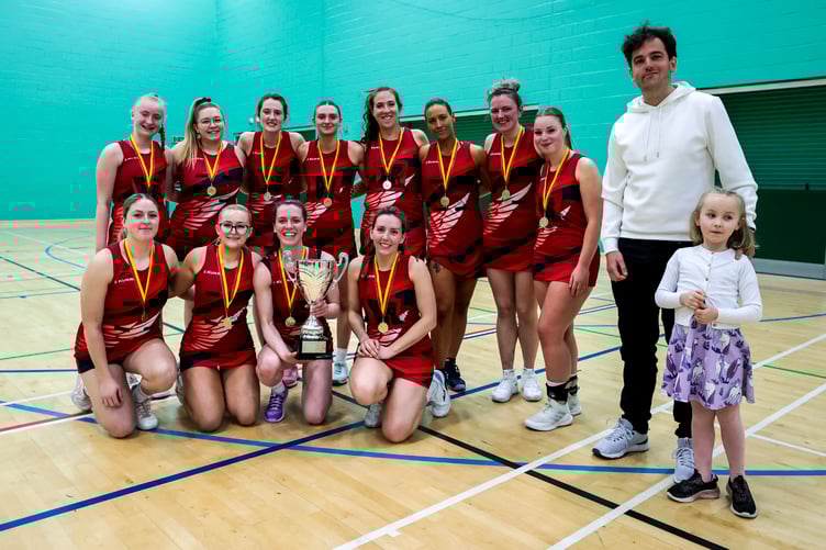 Simcocks Red celebrate with the impressive cup after winning 28-20 against Suntera Global Ballasalla Blizzards during the Judi Clark-Wilson Finals Day at the NSC recently. Also pictured is Judi's son Dave who presented the trophies on the day alongside one of her grandchildren, Seren Collister (Photo: Gary Weightman)