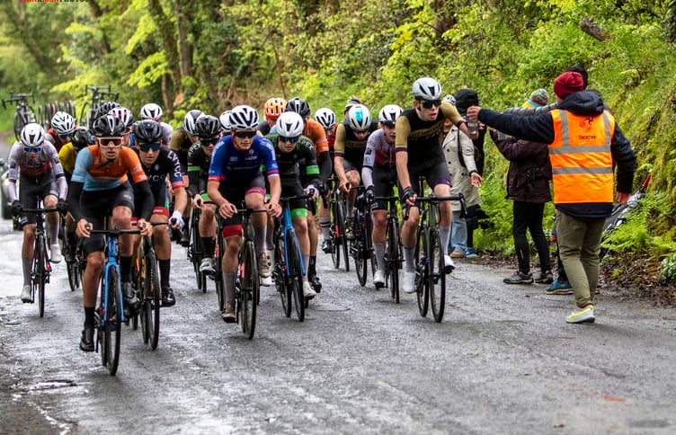 In soggy conditions, Utmost-Mezzo rider Ivan Sorby (far right) receives a bottle from his dad Rob in the feed zone during last weekend's Isle of Man Youth and Junior Cycling Tour. Ivan was second on the opening stage and 19th on stage two to finish third in the general classification (Photo: Gary Jones)