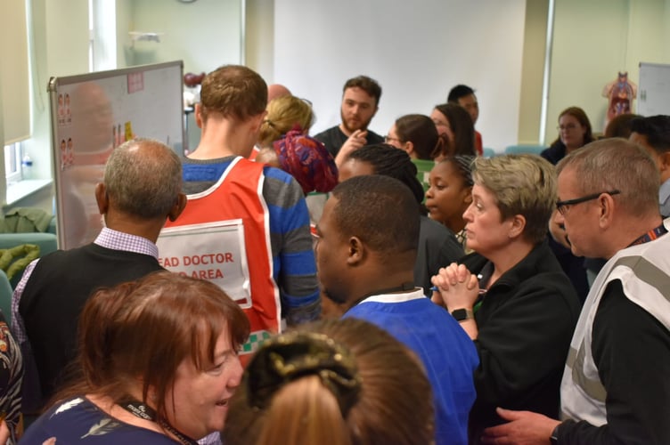 Emergency Department (ED) staff, as they discuss the coordination of resources to manage a sudden influx of contaminated patients