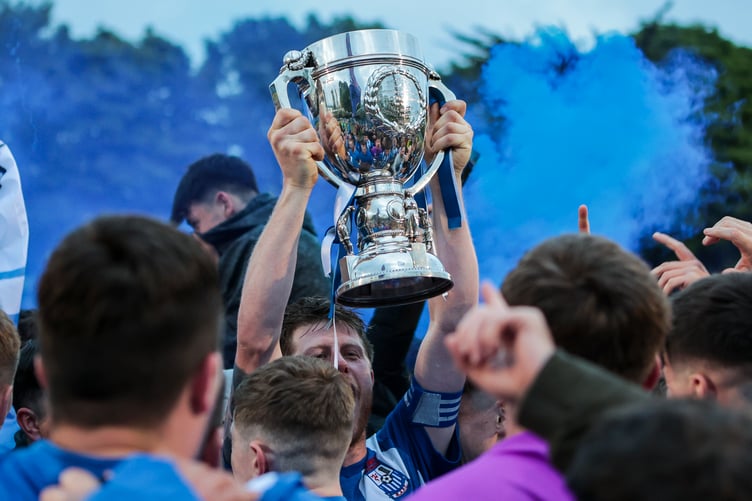 Surrounded by his players and fans, Ramsey AFC captain Matty Montgomery hoists the Hospital Cup aloft after the northerners defeated Laxey 2-1 in the final at the Bowl on Friday evening (Photo: Gary Weightman)