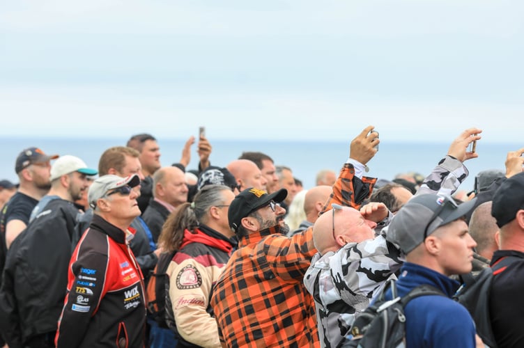 Plenty of onlookers take pictures and videos of the stunt riders at Peel TT Day