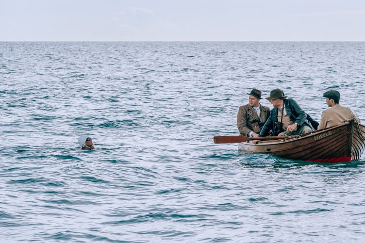 Scene of Kirsten Callaghan playing Mercedes Gleitze in film Vindication Swim with and boatmen