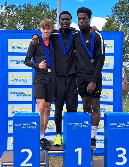 Regan Corrin (left) on the podium after winning a silver medal in the under-20s men’s age group at the Northern Athletics Track and Field Championships at Middlesborough last Saturday. The Manx athlete set a new island record with a jump of 7.07 metres (Photo: Northern Athletics)