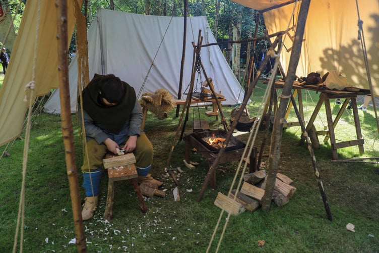 An honourary Viking carves wood in the Viking Village