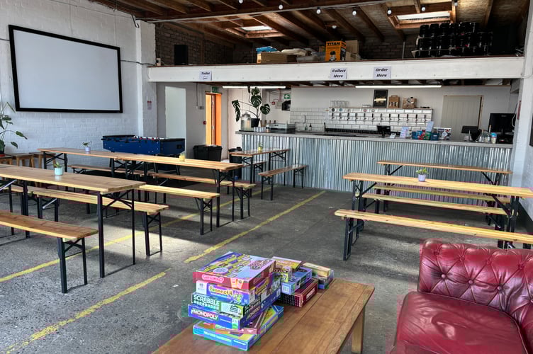 The new taproom, with board games, benches for seating and a bar