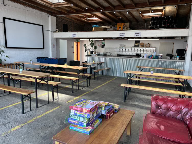The new taproom, with board games, benches for seating and a bar