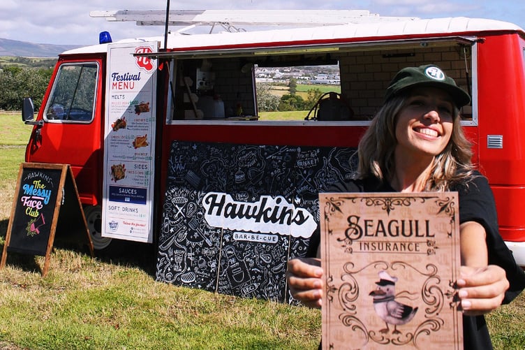 Hawkins BBQ head of operations Charlie Smith holding a copy of 'seagull insurance' now on offer to customers