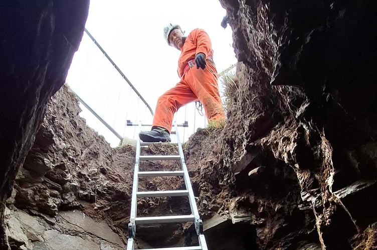 A member of the Laxey Mines Research Group peers down the sinkhole at the Chasms