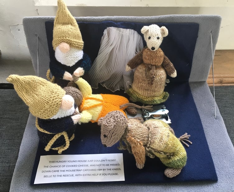 A display showing Belle rescuing a fellow mouse from a mouse trap