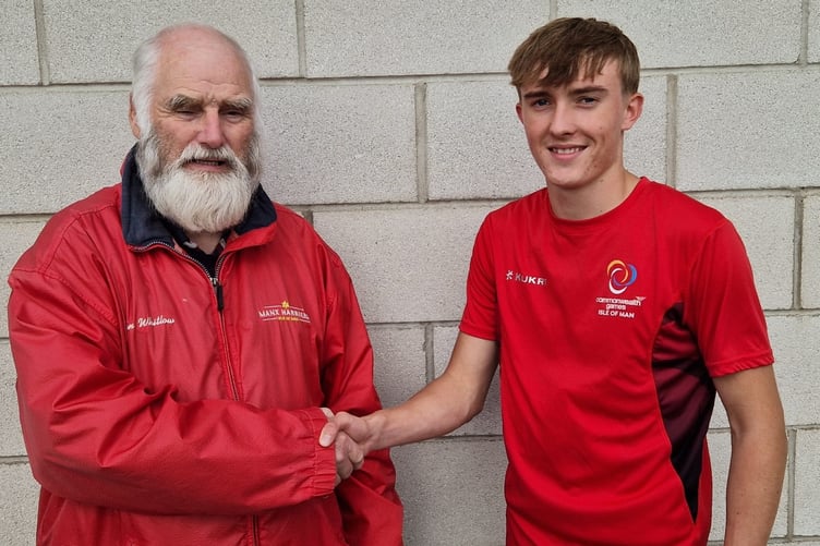 Regan Corrin being congratulated by his coach John Whitlow on being nominated as the Baker Tilly IoM Athlete of the Meeting for round five of the Track & Field League