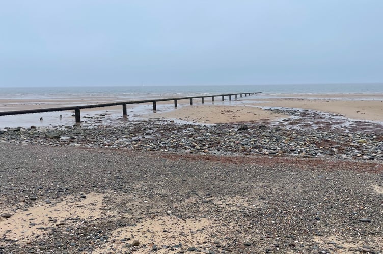 A pipe running down Jurby beach at low tide