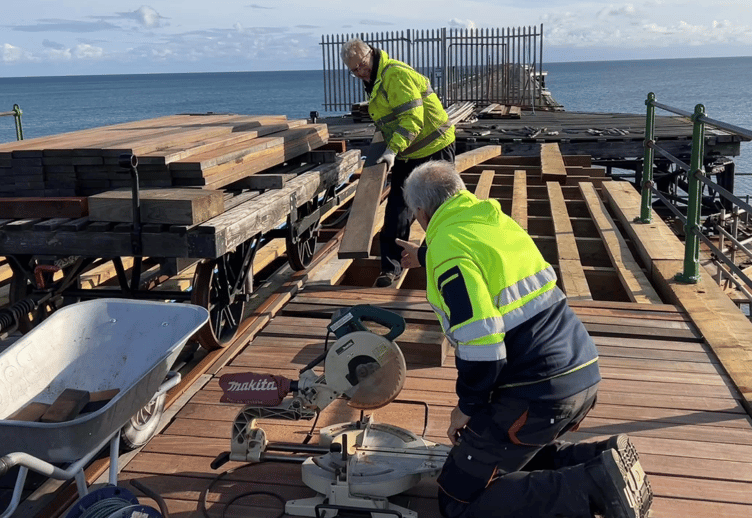 Volunteers busy laying planks on bay 8 of Queen's Pier