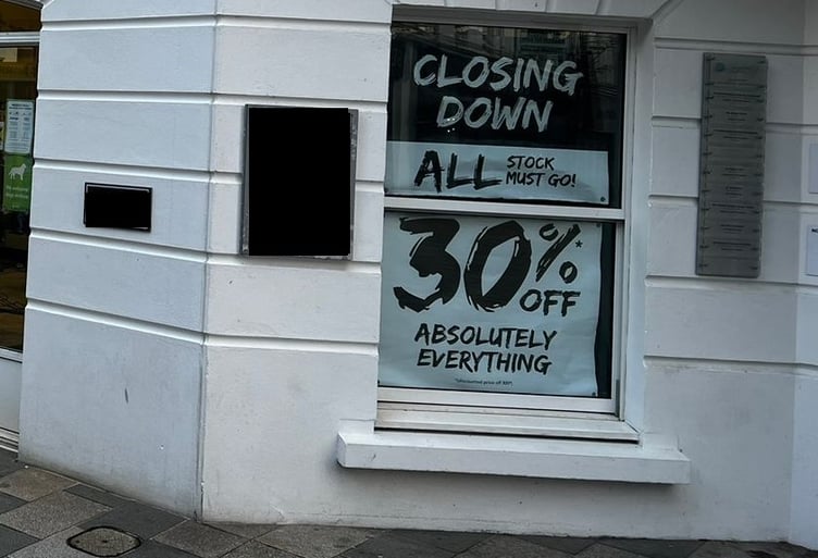 A 'closing down' sign in the window of Millets on Strand Street, Douglas
