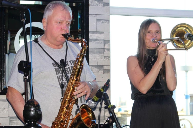 Jerry Carter playing the saxophone and Jackie Morrey-Grace on trombone