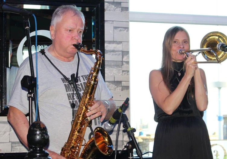 Jerry Carter playing the saxophone and Jackie Morrey-Grace on trombone