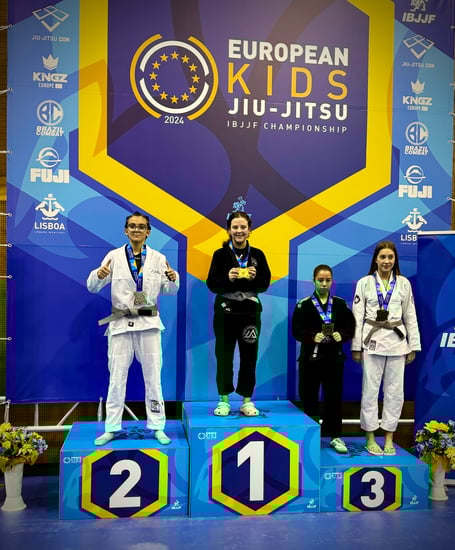 Summit Grappling Academy’s Hanako Henson (centre) on the top step of the podium after clinching a gold medal at the European Kids IBJJF Jiu-Jitsu Championship in Portugal
