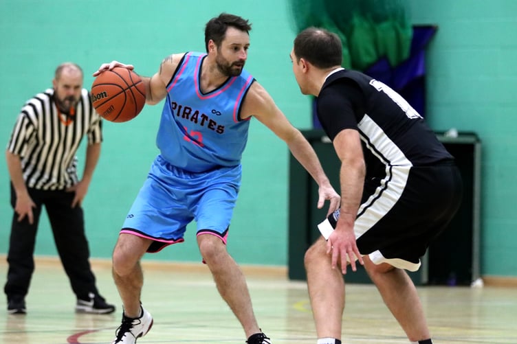 Pirates guard Jamie Grose shifts for the crossover as Jets' Michael Baker defends and referee Andy Corlett watches for any carry violations (Photo: Martin Dunne)