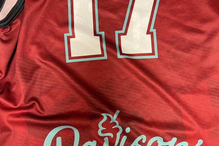 The new QEII High School basketball kit with Davison's ice cream logo on the back
