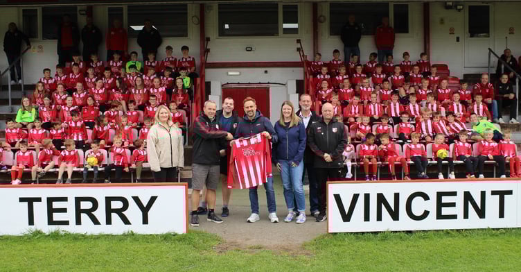 Pictured in the Terry Vincent Stand at Peel Football Club alongside some of the westerners' younger players are: (left to right) Peel junior committee members Sally Lawrence, Cliff Dunn, Steven Ferrario, Tim Groves from Black Grace Cowley, Kate Lowey, Stephen Preshous and Alex Perriam.