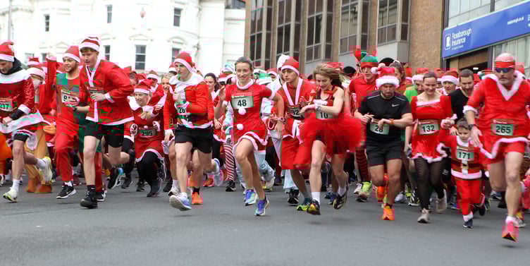 Nearly 270 runners set off from outside the Isle of Man Bank building on Prospect Hill for the annual Santa Dash around the streets of Douglas on Wednesday lunchtime. The race was won by Jordan Cain for the first time, with Jess Bryan (No.48) claiming the women's honours on eighth place overall (Photo: Dave Norton)